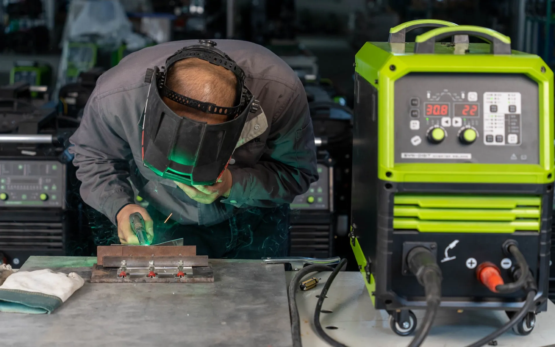 Live welding operation showing the machine, operator and weld test setup.