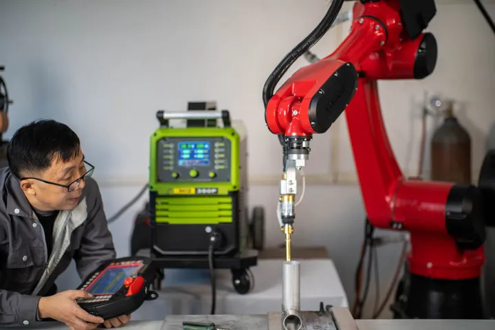 Robot welding setup with operator and welding machine